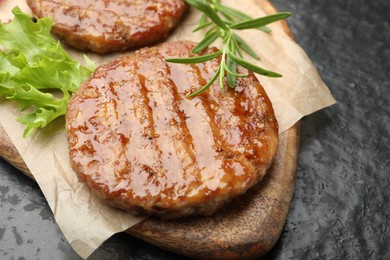 Photo of Delicious hamburger patties and spices on black table, closeup