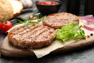 Photo of Delicious hamburger patties and spices on black table, closeup