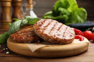 Photo of Delicious hamburger patties and spices on wooden table, closeup