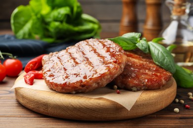 Photo of Delicious hamburger patties and spices on wooden table, closeup