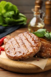 Photo of Delicious hamburger patties and spices on wooden table, closeup