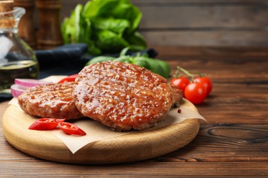 Photo of Delicious hamburger patties and spices on wooden table, closeup. Space for text