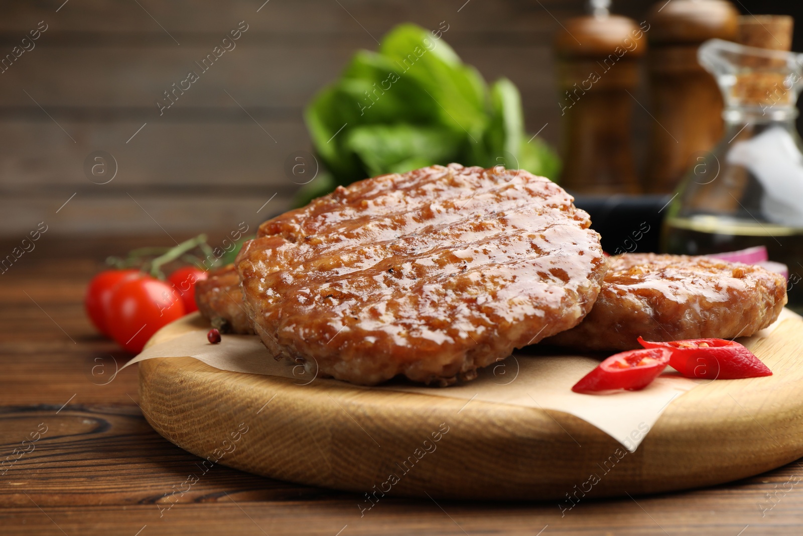 Delicious hamburger patties and spices on wooden table, closeup Photo of Delicious hamburger patties and spices on wooden table, closeup