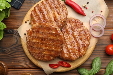 Photo of Delicious hamburger patties and spices on wooden table, flat lay