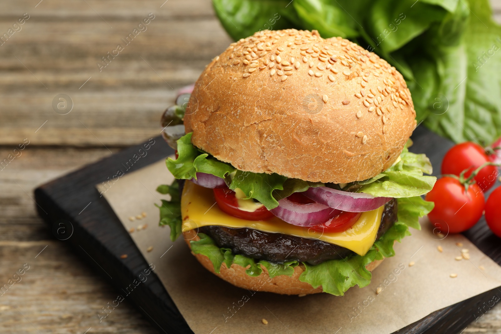 Delicious hamburger with patty and cheese on wooden table, closeup. Space for text Photo of Delicious hamburger with patty and cheese on wooden table, closeup. Space for text