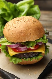 Photo of Delicious hamburger with patty and cheese on table, closeup