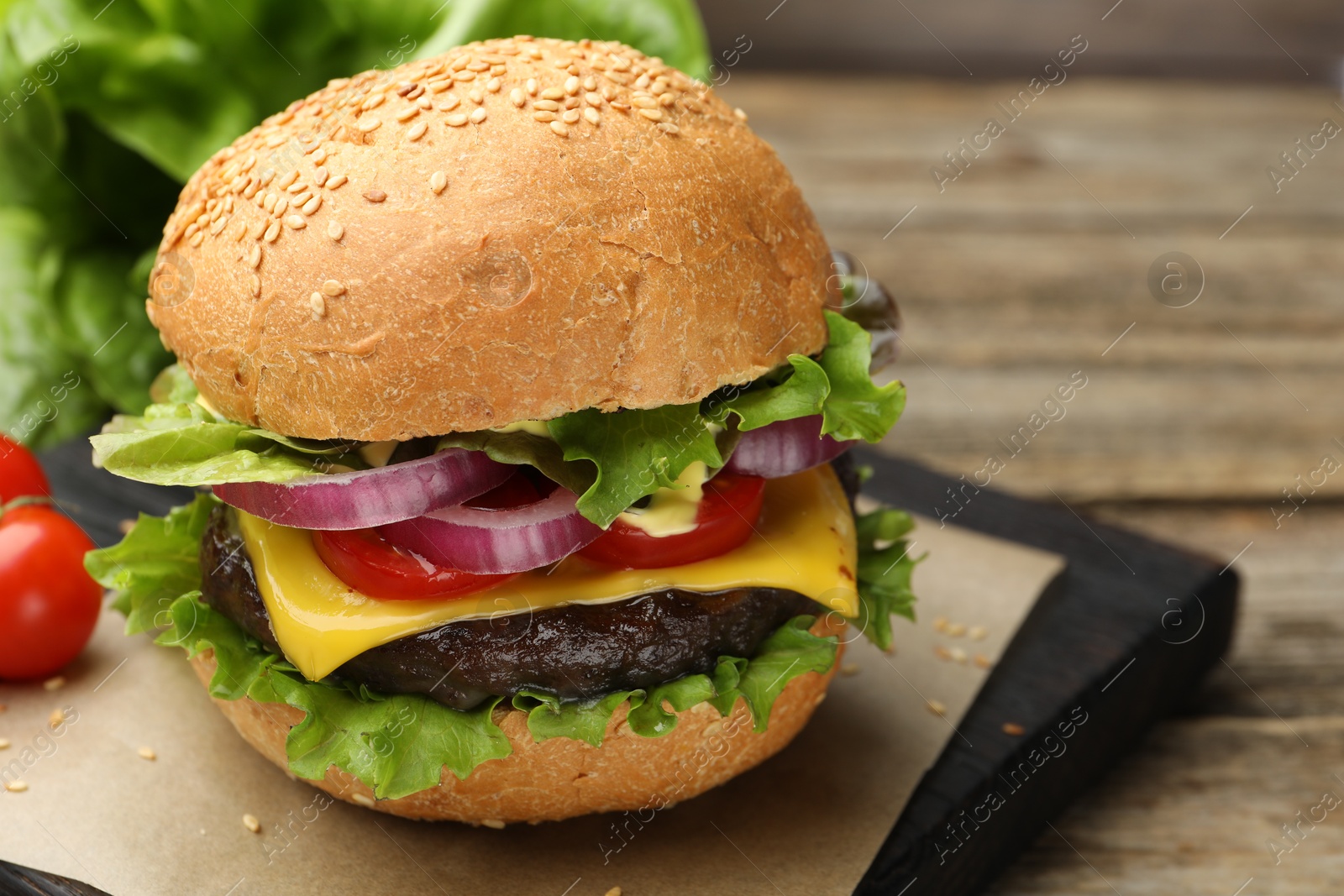 Delicious hamburger with patty and cheese on wooden table, closeup. Space for text Photo of Delicious hamburger with patty and cheese on wooden table, closeup. Space for text