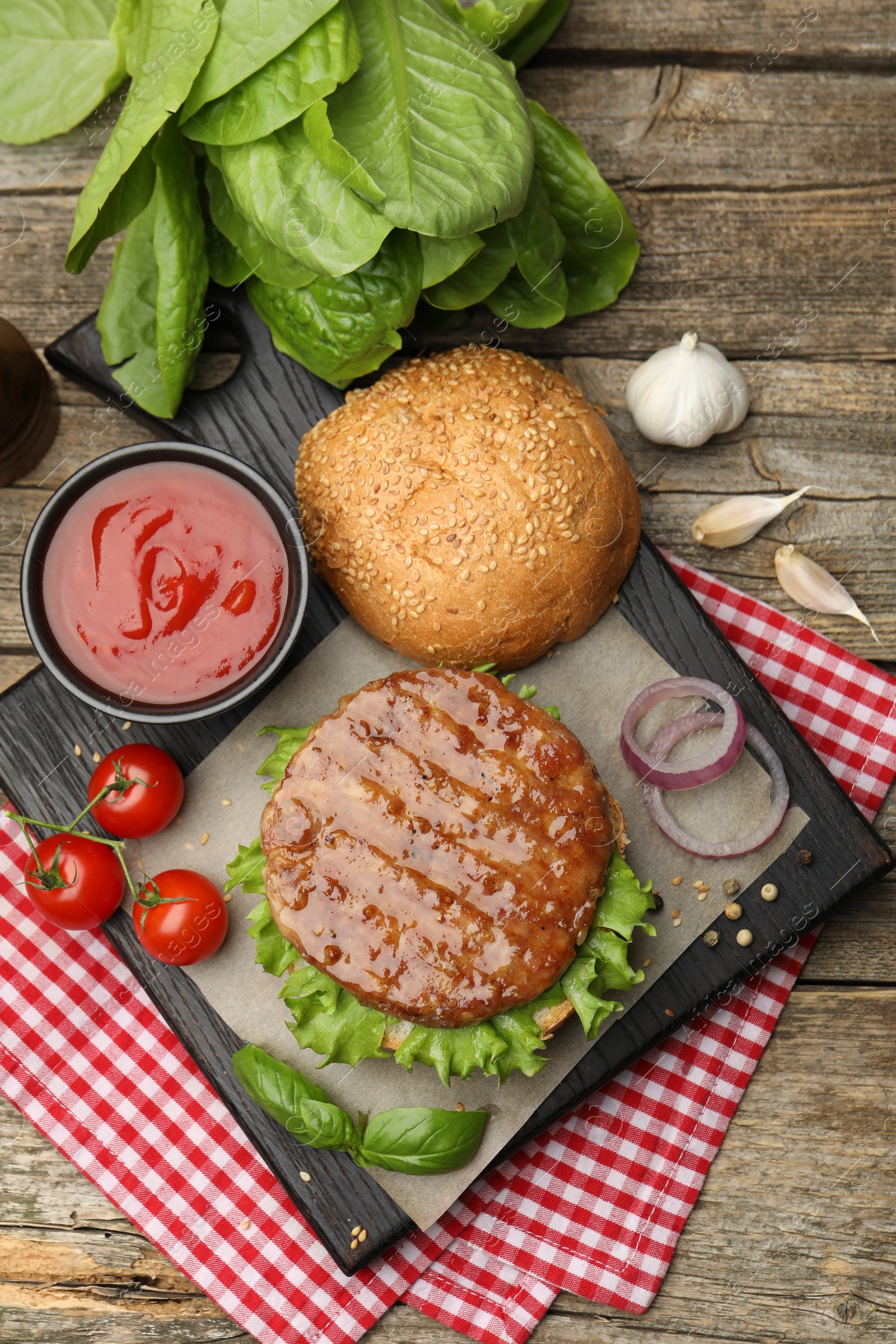 Delicious hamburger patty, bun, vegetables and spices on wooden table, flat lay Photo of Delicious hamburger patty, bun, vegetables and spices on wooden table, flat lay