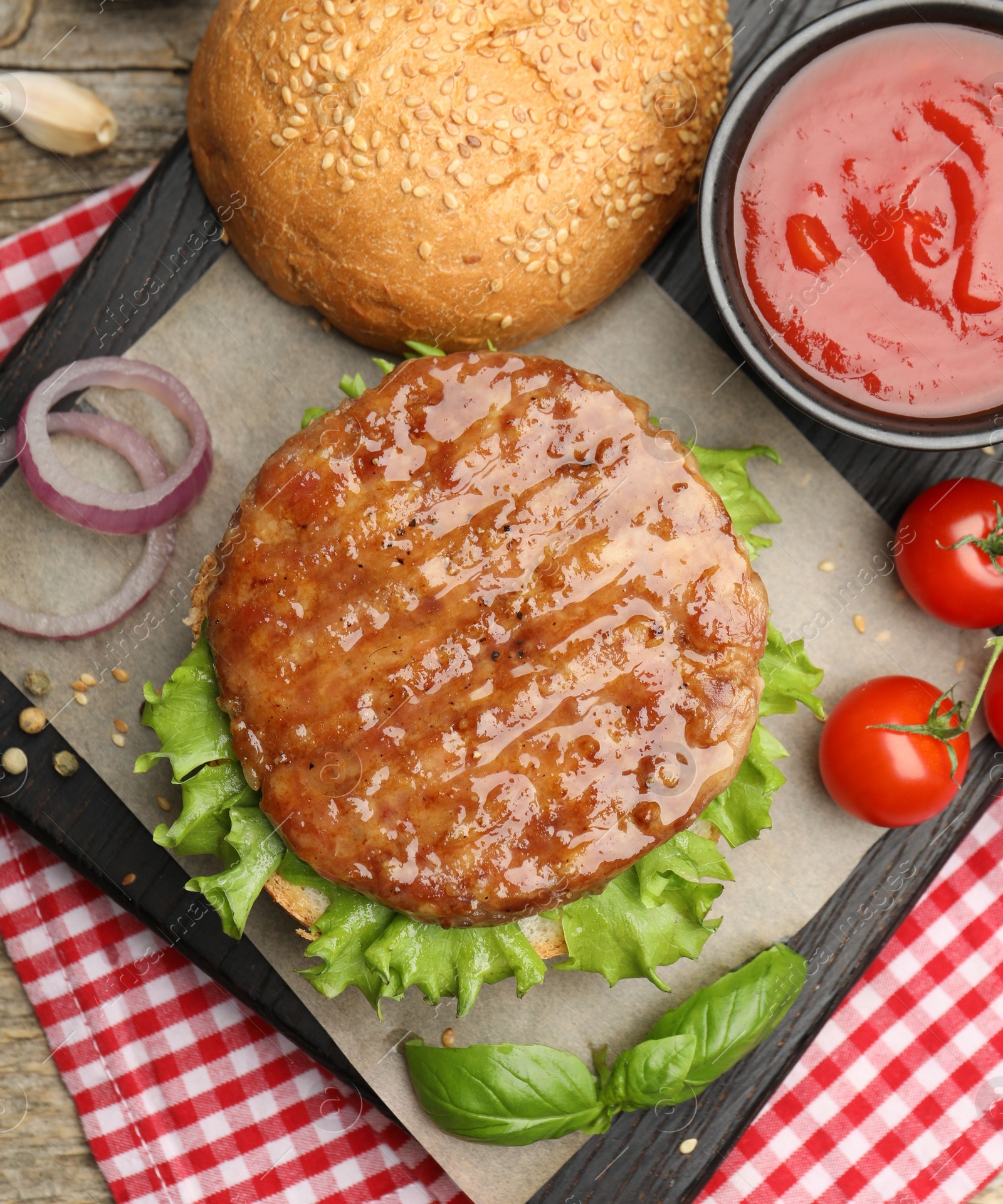 Delicious hamburger patty, bun, vegetables and spices on table, flat lay Photo of Delicious hamburger patty, bun, vegetables and spices on table, flat lay