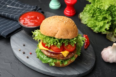 Photo of Delicious hamburger with patty served on black table, closeup