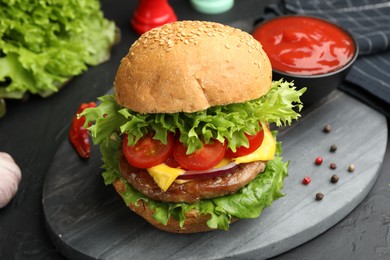 Photo of Delicious hamburger with patty served on black table, closeup