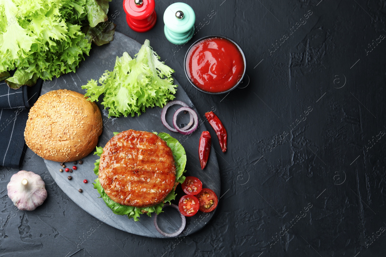 Delicious hamburger with patty served on black table, flat lay. Space for text Photo of Delicious hamburger with patty served on black table, flat lay. Space for text