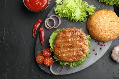 Photo of Delicious hamburger with patty served on black table, flat lay. Space for text