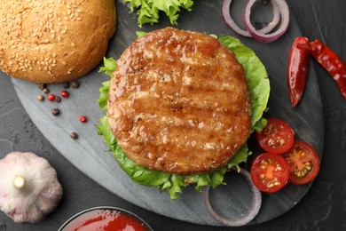 Photo of Delicious hamburger with patty served on black table, flat lay