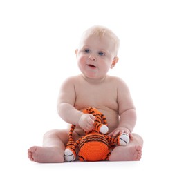 Photo of Cute little baby with knitted toy tiger on white background