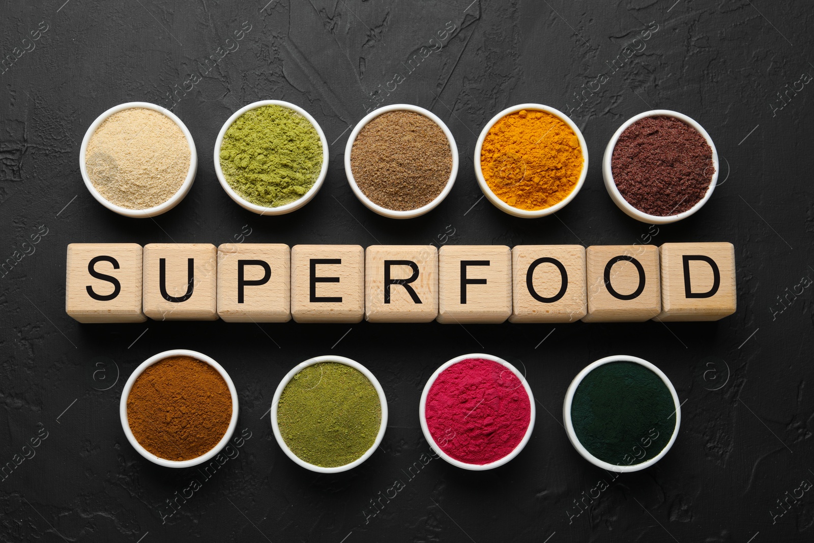 Different superfoods and word made of cubes on dark textured table, flat lay Photo of Different superfoods and word made of cubes on dark textured table, flat lay