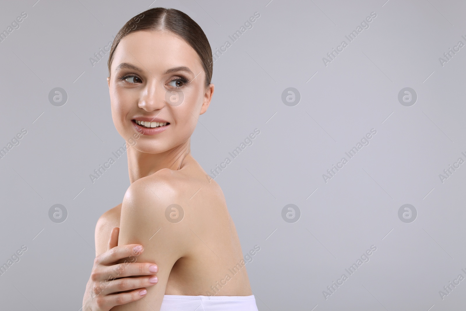 Photo of Portrait of beautiful young woman on gray background, space for text