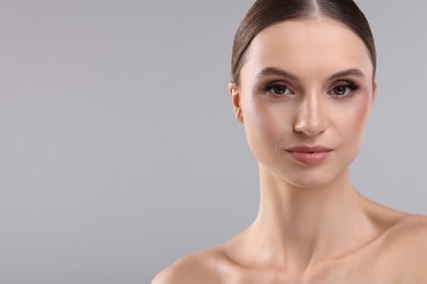 Photo of Portrait of beautiful young woman on gray background, space for text