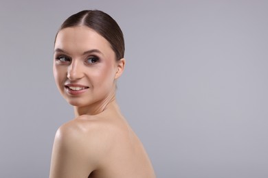 Photo of Portrait of beautiful young woman on gray background, space for text
