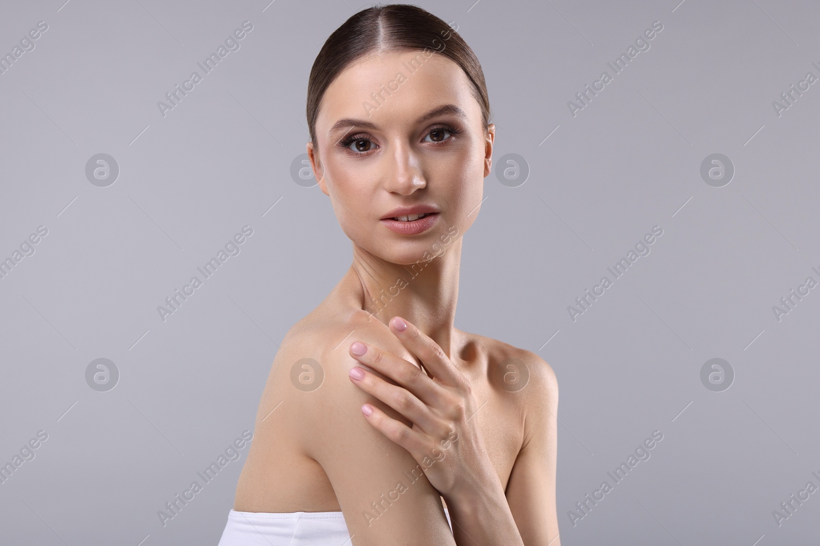 Portrait of beautiful young woman on gray background Photo of Portrait of beautiful young woman on gray background