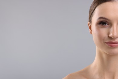 Photo of Portrait of beautiful young woman on gray background, closeup. Space for text