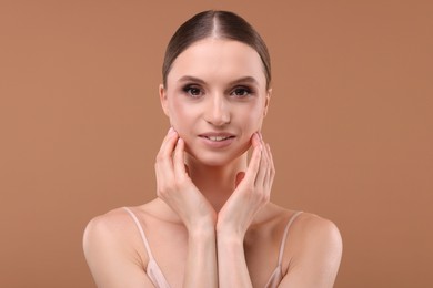 Photo of Portrait of beautiful young woman on beige background