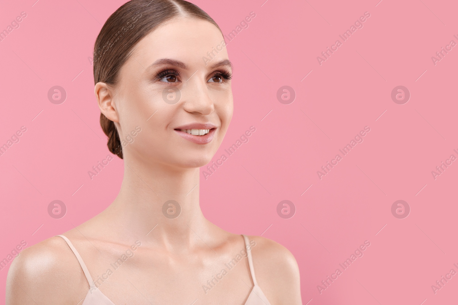 Photo of Portrait of beautiful young woman on pink background, space for text