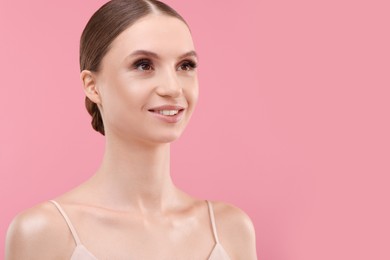 Photo of Portrait of beautiful young woman on pink background, space for text