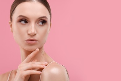 Photo of Portrait of beautiful young woman on pink background, space for text