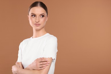 Photo of Portrait of beautiful young woman on beige background, space for text