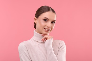 Photo of Portrait of beautiful young woman on pink background,