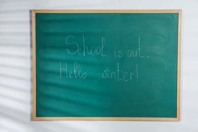 Photo of Phrases School Is Out and Hello Winter with exclamation mark on blackboard
