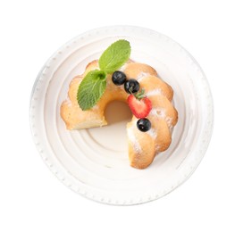 Photo of Tasty bundt cake with powdered sugar, berries and mint isolated on white, top view