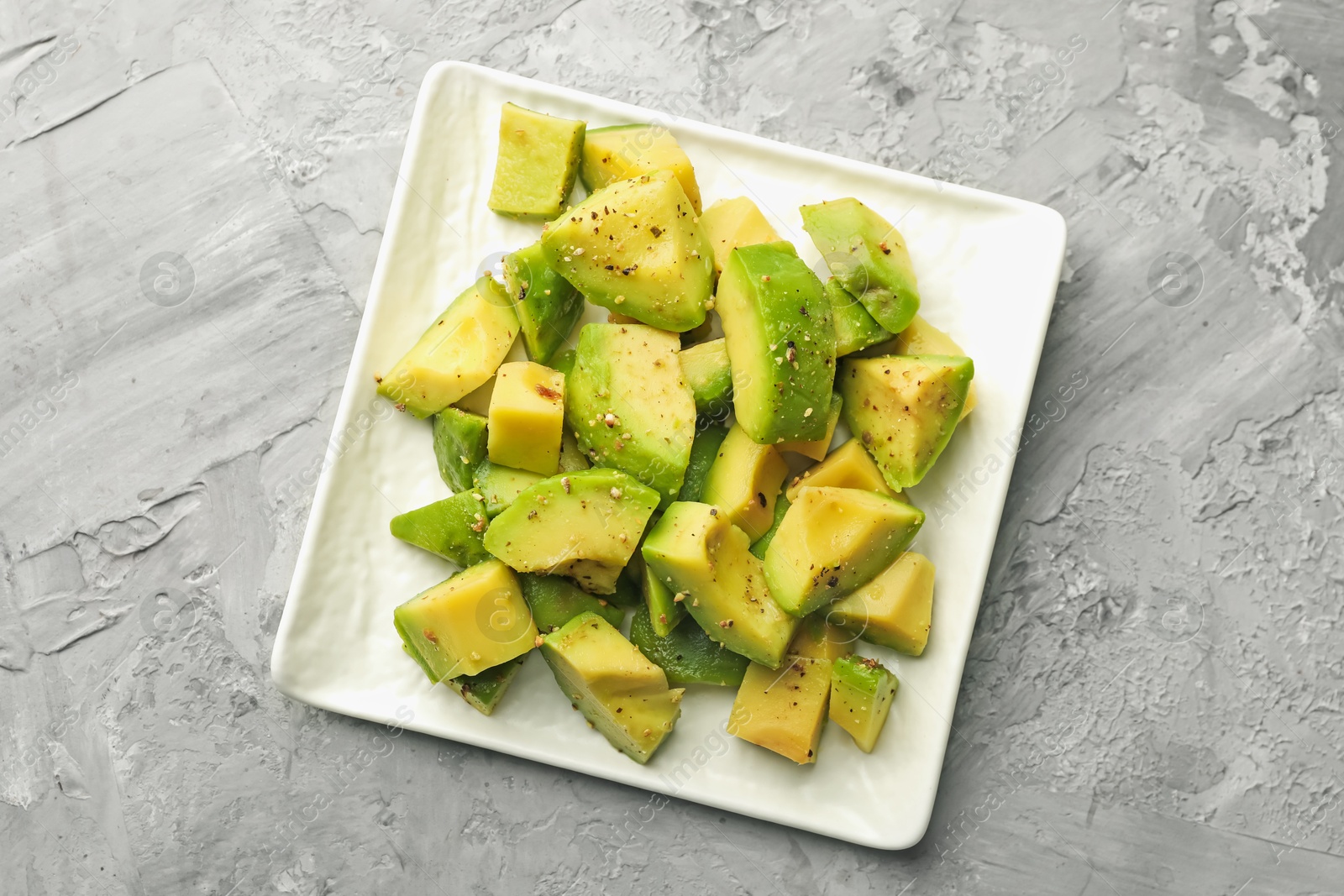 Tasty cut avocados with dressing on grey textured table, top view Photo of Tasty cut avocados with dressing on grey textured table, top view