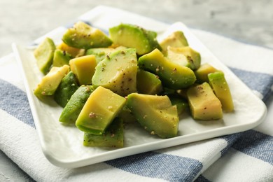 Photo of Tasty cut avocados with dressing on table, closeup