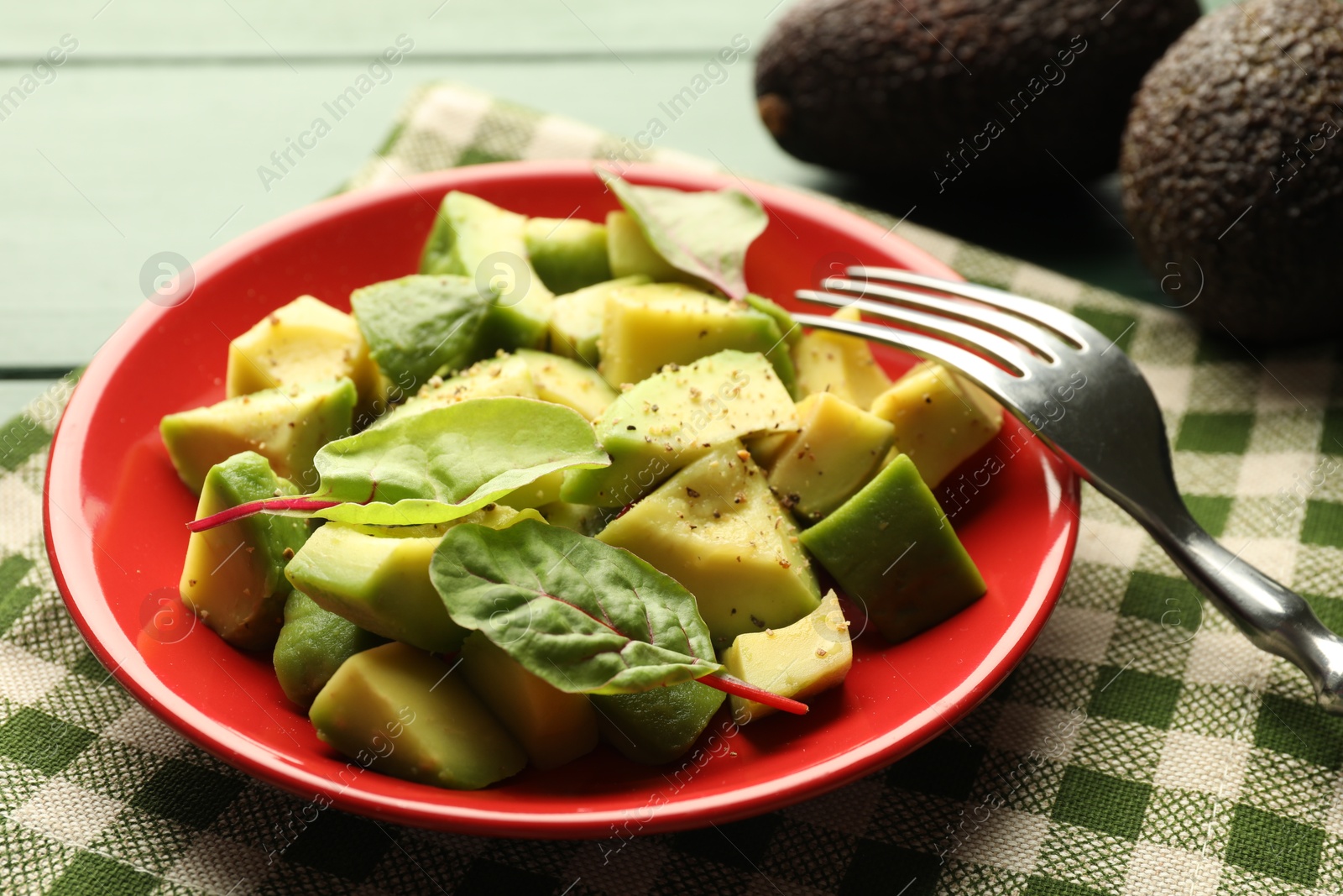 Tasty cut avocados with spinach and dressing on green wooden table, closeup Photo of Tasty cut avocados with spinach and dressing on green wooden table, closeup
