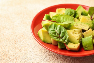 Photo of Tasty cut avocados with spinach and dressing on light textured table, closeup. Space for text