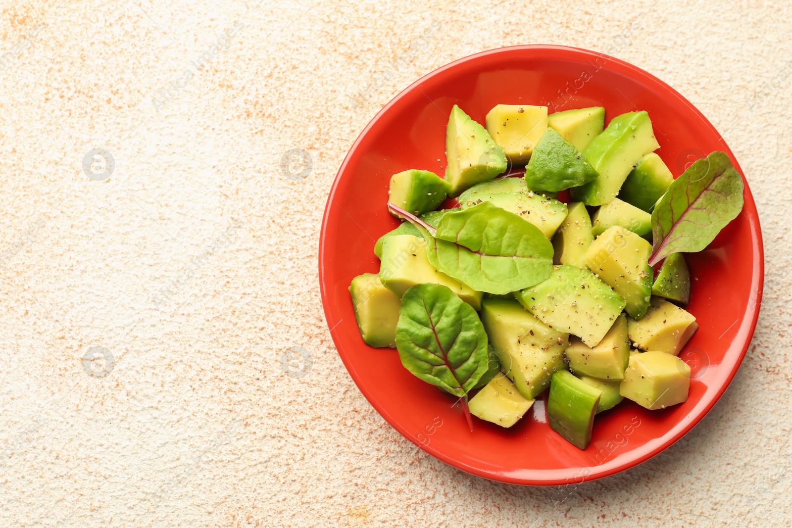 Tasty cut avocados with spinach and dressing on light textured table, top view. Space for text Photo of Tasty cut avocados with spinach and dressing on light textured table, top view. Space for text