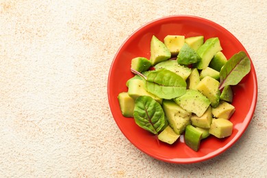 Photo of Tasty cut avocados with spinach and dressing on light textured table, top view. Space for text