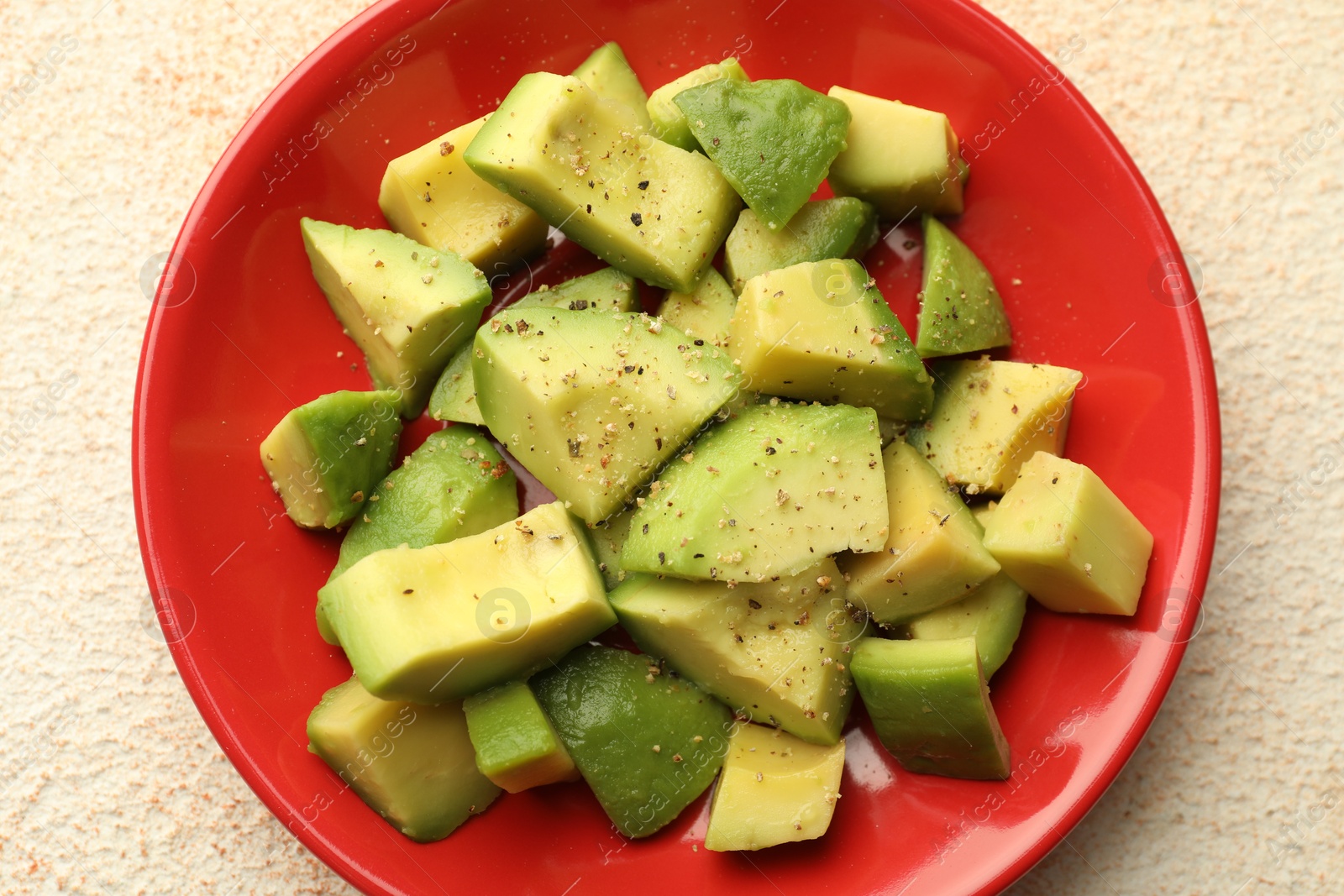 Tasty cut avocados with dressing on light textured table, top view Photo of Tasty cut avocados with dressing on light textured table, top view
