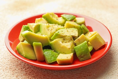 Photo of Tasty cut avocados with dressing on light textured table, closeup