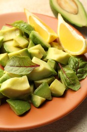 Photo of Tasty cut avocados, spinach and lemon on light textured table, closeup