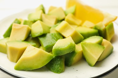 Photo of Tasty cut avocados and lemon on white table, closeup