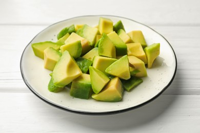 Photo of Tasty cut avocados on white wooden table, closeup