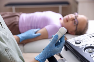 Photo of Sonographer with ultrasound machine and girl on examination bed in clinic, selective focus