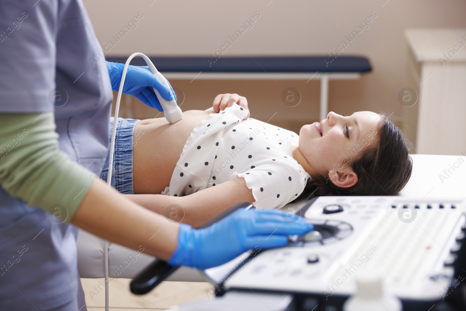 Sonographer conducting girl's abdominal ultrasound examination in clinic, closeup Photo of Sonographer conducting girl's abdominal ultrasound examination in clinic, closeup