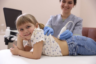 Photo of Sonographer conducting little girl's renal ultrasound examination in clinic, closeup