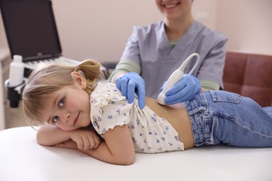 Photo of Sonographer conducting little girl's renal ultrasound examination in clinic, closeup
