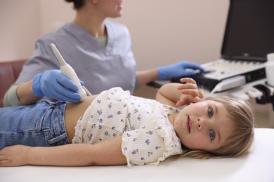 Photo of Sonographer conducting little girl's abdominal ultrasound examination in clinic, closeup