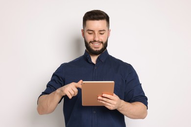 Photo of Handsome man using tablet on white background
